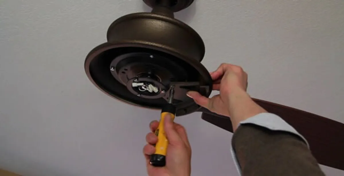 Electrician installing ceiling fan mounting bracket and fixture in Oklahoma City, OK